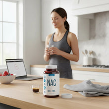 TRUEVANTAGE NUTRITION NAC 1000mg supplement bottle on a kitchen counter with a woman in the background.
